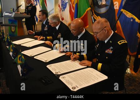 Il capo degli affari internazionali presso il Brasile Ministero della Difesa, Ammiraglio di Guilherme Da Silva Costa(al centro a destra) e New York La Guardia Nazionale aiutante gen., il Mag. Gen. Raymond le protezioni (a destra), il segno di un membro di un accordo di associazione, sul Museo della Portaerei U.S.S. Intrepid, Manhattan, N.Y., Marzo 14, 2019. Admiral Craig Faller, il comandante degli Stati Uniti Comando Sud ( centro sinistra) e il generale Joseph Lengyel, capo della Guardia Nazionale Bureau (estrema sinistra) ha preso parte anche il caso di firma. Lo stato del partenariato tra il New York La Guardia Nazionale e il Brasile è un Dipartimento della Difesa securit comune Foto Stock