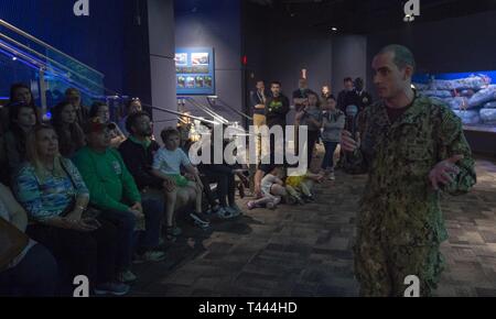 CHARLESTON S.C. (16 marzo 2019) subacqueo della Marina Militare di prima classe Hudzik Giosuè, Mobile Diving e unità di soccorso 2, parla di acquario visitatori presso il South Carolina Aquarium durante Charleston Navy settimana, 16 marzo. La Marina programma settimana serve come la Marina Il principale sforzo di divulgazione nelle aree del paese senza una significativa presenza della Marina. Foto Stock