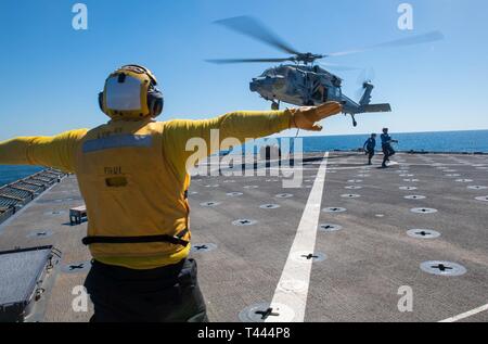 OCEAN (16 marzo 2019) di Boatswain Mate 2a classe John Robert Davis Jr. da Santa Paula, California, segnali ad un pilota di volare un MH-60S Sea Hawk elicottero, attaccato al mare in elicottero Combat Squadron (HSC) 21 come si libra durante un rifornimento verticale a bordo della harpers Ferry-classe dock anfibio sbarco nave USS harpers Ferry (LSD 49). Harpers Ferry è in corso conducendo le operazioni di routine come una parte di USS Boxer anfibio gruppo pronto (ARG) nell'Oceano Pacifico orientale. Foto Stock