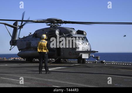 OCEAN (16 marzo 2019) di aviazione di Boatswain Mate (movimentazione) terza classe Michael Burns, da Jackson, Miss., assegnato a Amphibious Assault nave USS Boxer (LHD 4), orologi un CH-53E Super Stallion attaccata al mezzo marino Tiltrotor Squadron (VMM) 163 prima del decollo sul ponte di volo. Boxer in corso è di condurre le operazioni di routine come una parte di USS Boxer anfibio gruppo pronto (ARG) nell'Oceano Pacifico orientale. Foto Stock