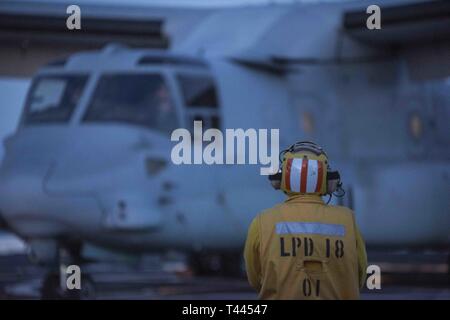 Oceano Pacifico (16 marzo 2019) - Capo di aviazione di Boatswain Mate (carburazione) Roydominic Guerrero supervisiona la manipolazione di un MV-22B Osprey dal mezzo marino Tiltrotor Squadron 164 sul ponte di volo della USS New Orleans (LPD 18) durante l'esercizio pacifico Blitz 19. Pacific Blitz è uno scenario-driven esercizio congiunto che fornisce corsi di formazione pertinenti dalla replica di una realistica minaccia marittima ambiente concepito per stimolare e migliorare la capacità anfibie necessaria per una effettiva crisi globale risposta. Foto Stock