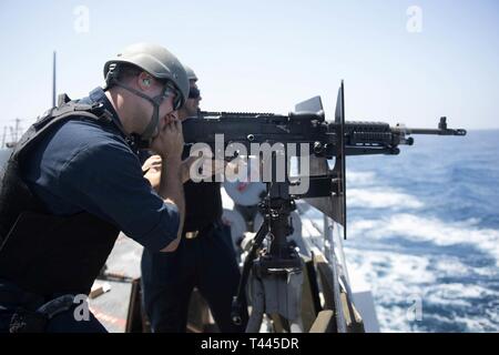 Stati Uniti Marina di Boatswain Mate 2a classe Brian Bruni, da Kingston, Massachusetts, incendi un M240B mitragliatrice durante un equipaggio servito armi corso di qualificazione a bordo guidato-missile destroyer USS Spruance (DDG 111) nell'Oceano Indiano, 16 marzo 2019. Il Spruance è distribuito negli Stati Uniti Quinta Flotta area di operazioni a sostegno di operazioni navali per garantire stabilità marittimo e la sicurezza nella regione centrale di collegamento del Mediterraneo e del Pacifico attraverso l'Oceano Indiano occidentale e tre strategici punti di strozzatura. Foto Stock