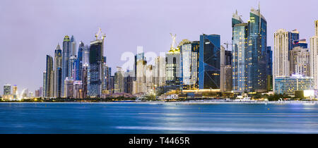 Meravigliosa vista panoramica della illuminata Dubai Marina skyline durante il tramonto. Foto scattata da Palm Jumeirah arcipelago artificiale. Foto Stock