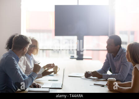 Diversi imprenditori gruppo sedersi a un tavolo per conferenza negoziare in sala riunioni Foto Stock