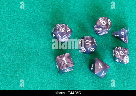 Grigio dadi poliedrica per Dungeons and Dragons gioco da tavolo a giocare sul green baize tabella con copyspace Foto Stock