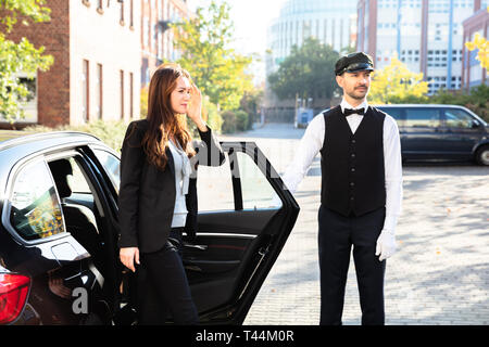 Donna in tacchi alti per uscire dall'auto Foto Stock