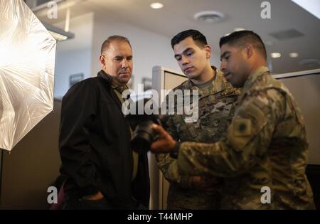 David Loeffler, Visual Information Manager per la California Dipartimento Militare, sinistro funziona con California Esercito Nazionale soldati di guardia, U.S. Army Spc. Jonathan Franco, 1° Battaglione, campo 144reggimento di artiglieria, centro e Sgt. 1. Classe Ramon Garibaldi della 40a divisione di fanteria, a destra per rivedere l'esposizione, l'illuminazione e la composizione di un ritratto, febbraio 20, 2019, durante un dipartimento della Foto Stock