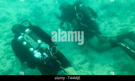 SANTA RITA, Guam (feb. 20, 2019) Sri Lanka navy Capt. Varuny Ferdinandusz, destra comunica con Marina subacqueo 2a classe Rabideau Andre, un subacqueo di sicurezza assegnato al mobile di immersioni subacquee e di unità di soccorso (MDSU) 1, durante il corso di formazione in preparazione per esercitare la cooperazione a galla la prontezza e la formazione (Carati) Sri Lanka 19. Questo pre-allenamento è stato progettato per familiarizzare il di Sri Lanka team con attrezzature e pratiche che portano fino a caso a partire da aprile. Foto Stock