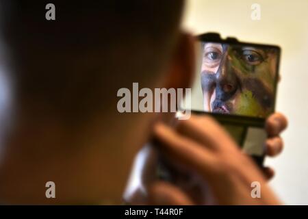 Stati Uniti Il personale dell'esercito Sgt. Daniel G. Campbell, paracadutista assegnato per la cinquantaquattresima brigata battaglione ingegnere , 173rd Airborne Brigade mette i tocchi di rifinitura per il suo volto vernice mimetica in preparazione per le operazioni di volo su Giulietta Drop Zone di Pordenone, Italia Feb 21, 2019. Il 173rd Brigata aerea è l'U.S. Esercito di risposta di emergenza forza in Europa, in grado di proiettare le forze di pronto ovunque negli Stati Uniti Europeo, Africa Centrale o comandi in aree di responsabilità. Foto Stock