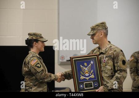 Stati Uniti Esercito Lt. Col. Michael Girvin, destra, comandante uscente della 2-104th supporto generale del battaglione di aviazione, 28 Expeditionary combattere la Brigata Aerea, scuote le mani con e riceve un dono dal comando Sgt. Il Mag. Shannon Cullen, il comando sergente maggiore dell'2-104th GSAB, durante un cambio del comando cerimonia al ventottesimo ECAB armory, 24 febbraio 2019. Girvin fu onorato e ha ringraziato per il suo servizio durante la cerimonia. Foto Stock