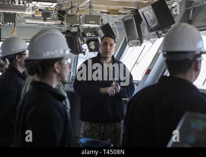 NEWPORT NEWS, Va. (feb. 25, 2019) Capo Quartermaster Jose Triana, assegnato USS Gerald Ford (CVN 78) dipartimento di navigazione, mutandine membri del destroyer Squadron 22 personale durante un tour evidenziando Ford funzionalità. Ford è attualmente in fase di post-shakedown disponibilità presso Huntington Ingalls Industries-Newport News la costruzione navale. Foto Stock