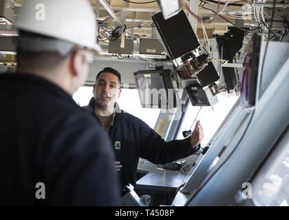 NEWPORT NEWS, Va. (feb. 25, 2019) Capo Quartermaster Jose Triana, assegnato USS Gerald Ford (CVN 78) dipartimento di navigazione, mutandine membri del destroyer Squadron 22 personale, durante un tour di Ford di evidenziazione delle sue funzionalità. Ford è attualmente in fase di post-shakedown disponibilità presso Huntington Ingalls Industries-Newport News la costruzione navale. Foto Stock