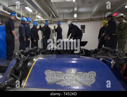 NEWPORT NEWS, Va. (feb. 27, 2019) velisti assegnati alla USS Gerald Ford (CVN 78) coperta preparare per il sollevamento di Ford in catena di ancoraggio su un wildcat. Ford è attualmente in fase di post-shakedown disponibilità presso Huntington Ingalls Industries-Newport News la costruzione navale. Foto Stock