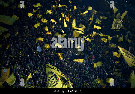 Dortmund, Germania. Xiii Apr, 2019. Calcio: Bundesliga, Borussia Dortmund - FSV Mainz 05, XXIX Giornata al Signal Iduna Park. Gli appassionati di Dortmund wave loro bandiere prima della partita. Credito: Ina Fassbender/dpa - NOTA IMPORTANTE: In conformità con i requisiti del DFL Deutsche Fußball Liga o la DFB Deutscher Fußball-Bund, è vietato utilizzare o hanno utilizzato fotografie scattate allo stadio e/o la partita in forma di sequenza di immagini e/o video-come sequenze di foto./dpa/Alamy Live News Foto Stock