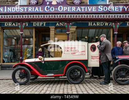 Il museo Beamish, Beamish, Contea di Durham, England, Regno Unito, 13 aprile 2019. Beamish vapore giorno: uomo vestito in abiti d'epoca con l'annata 1928 Austin consegna van con Bernard Matthews turchia agricoltore logo sul display a Beamish museo vivente al di fuori di società cooperativa shop Foto Stock