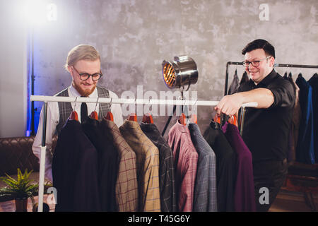 Matura sarto professionale prendendo le misure per la cucitura di adattarsi al negozio di sartoria. Uomo con nastro di misurazione occupato. Exclusive Custom made tela concetto. Foto Stock