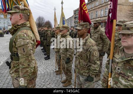 SKWIERZYNA, Polonia (feb. 23, 2019) - Un plotone di soldati dal 101st brigata battaglione di supporto, 1° Brigata corazzate contro la squadra, 1a divisione di fanteria, assistere ad una cerimonia a sostegno di 61 polacco cadetti prestando giuramento di difendere e di servire il proprio paese, nel centro della città. Foto Stock