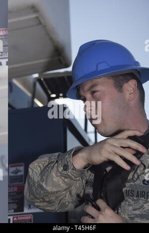 Stati Uniti Air Force Airman Benjamin Moran, centesimo ingegnere civile squadrone sistemi elettrici apprendista, regolare nuovamente il suo ingranaggio di sicurezza prima di procedere alla sostituzione di una lampada di strada a RAF Mildenhall, Inghilterra, Feb 25, 2019. La sostituzione della lampadina si salva RAF Mildenhall denaro in sostituzione di luci e lampadine, elettricità e ore-uomo. Foto Stock