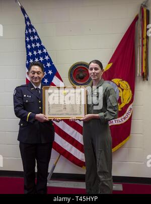 Il colonnello Takaoka (sinistra) presenta il Mag. Tina D. Terry (destra) con un certificato di apprezzamento su Marine Corps Air Station Futenma, Okinawa, in Giappone, Feb 26, 2019. Il premio è stato consegnato a Terry per le sue azioni come leader di volo in una MV-22B Osprey elicottero revisione di truppe al di sopra del Giappone Self Defence Force anniversario parade. Questa cerimonia e le prestazioni dei Marines aggiudicati dimostra la forte alleanza tra le forze degli Stati Uniti e il Giappone il primo ministro e il comandante supremo del Giappone sia a livello nazionale che all'estero. Terry è una MV-22B Osprey pilota con mezzo marino Tiltrotor Squadro Foto Stock