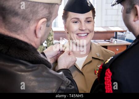 Grandi laghi, Ill. (5 marzo 2019) Da elettricista, mate 1. Classe Racquel Gunnell sorrisi come Capt. Erik Thors, comandante del reclutamento di formazione di comando (RTC) e RTC il comando Master Chief David Twiford pin dei dispositivi a collare sul suo uniformi durante una sorpresa cerimonia di promozione. Gunnell era uno dei quattro marinai RTC promosso a petty officer di prima classe sotto la marina è meritorio Programma di avanzamento, quali comandanti dà la possibilità di riconoscere i loro migliori velisti facendole avanzare quando sono pronti per il prossimo livello di responsabilità. Più di 35.000 reclute graduate annualmente dal N Foto Stock