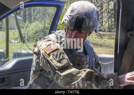 Nazionale della Georgia, Guardsman Sgt. Matthew Taylor, rappresentando il Columbus a base di manovra 648th brigata di miglioramento, le ricerche all'interno del veicolo per articoli proibiti durante la ricerca e il sequestro valutazione al membro guerriero migliore concorrenza a Fort Stewart, Georgia il 8 marzo 2019. I concorrenti erano tenuti a verificare identificazioni, ricercare e sequestrare qualsiasi oggetti vietati e segnalare gli elementi al proprio supervisore. Stati Uniti Esercito nazionale Guard Foto Stock