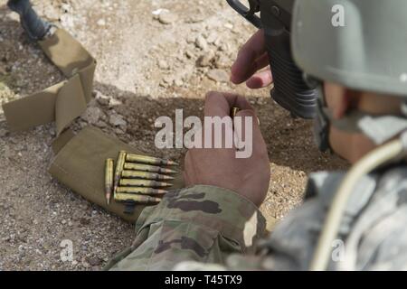 Army Spc. Johnny Carrasco, una gestione finanziaria tecnico con la 159Gestione Finanziaria DISTACCO SUPPORTO, carichi di munizioni nel M249 arma automatica della squadra nel corso delle qualifiche a Firenze prenotazione militare poligono di tiro il 8 marzo 2019. Dopo azzeramento le loro armi, i soldati devono ricevere un punteggio minimo di 35 in burst controllata al fine di passare la qualificazione dell'esercito sulla M249 arma automatica della squadra. Foto Stock