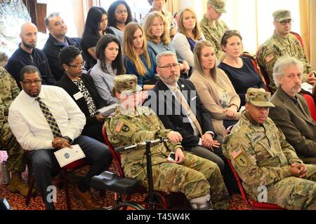 I soldati e i membri della famiglia si riuniscono per la modifica del comando di U.S. Army Health Clinic di Ansbach alla Von Steuben centro comunitario in Ansbach, Germania, 8 marzo 2019. Durante la cerimonia, Col. Burke Bristow (comandante uscente), lasciò il comando di Lt. Col. Daniel contanti (comandante in arrivo). Foto Stock