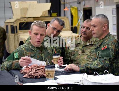L'Iowa Guardia nazionale, in collaborazione con la Guardia Nazionale Supporto Training Center (STC) situato a Camp Dodge manovra congiunta Training Center ospita soldati provenienti da diversi paesi balcanici durante un giro Humvee manutenzione corso di gestione. Sgt. Il Mag. George Dezenzo, Senior Operations Sgt., New Jersey esercito nazionale Guard e soldati albanesi rivedere il mantenimento dei dati durante un Humvee controllo di manutenzione. Foto Stock