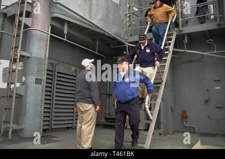 Educatore museale Giuseppe Miechle di Hampton Roads Museo Navale, sorge al di sotto di una scala come volontari scendere durante un tour guidato del Ticonderoga-Class Missile Cruiser USS Gettysburg (CG 64). Foto Stock