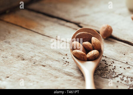 Mandorle versare dal cucchiaio di legno Foto Stock