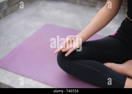 Donna asiatica rilassarsi in vacanza. Giocare se lo yoga. Sul balcone Foto Stock