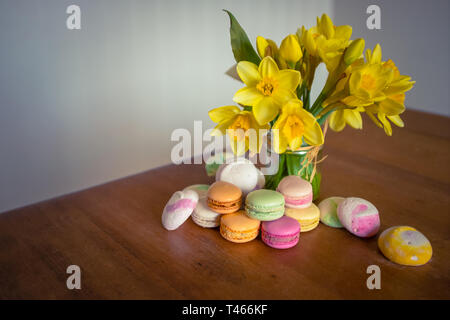 Fiori e Macarons su un rustico di paese vecchio tavolo da cucina con spazio di copia Foto Stock