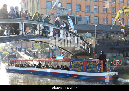 Barge con turisti di passaggio attraverso il Camden Lock sul Regents Canal, nel sole primaverile, a nord di Londra, Regno Unito Foto Stock