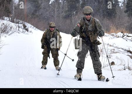 Il freddo leader 19-004 del corso gli studenti sci lungo il sentiero Hippie dopo la porzione di sparo di dieci chilometri di biathlon a la guerra del nord del centro di formazione di Black Rapids Sito di formazione Marzo 12, 2019. Il freddo in corso i Leader squadra treni- e plotone di dirigenti di livello in le conoscenze e le competenze necessarie per svolgere con successo le piccole operazioni unitarie in un freddo, coperto di neve e ambiente. L accento è posto sugli effetti del freddo sul personale e materiale, uso di basic freddo di abbigliamento e attrezzature, campo invernale craft, con le racchette da neve e piste tecniche e in inverno o regioni fredde navigati Foto Stock