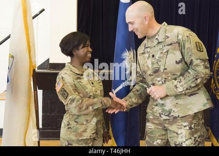 Lt. Col. Linda Riedel, centoventicinquesimo Cyber Protection comandante del battaglione, riceve una sfida moneta da Lt. Col. Prezzo Ryan, comandante della 228th brigata di segnale dopo un trasferimento di autorità cerimonia al Fort Meade, Maryland, Marzo 13, 2019. Riedel trasferisce competente della Task Force eco al comandante in arrivo Lt. Col. Michael Courville. Circa 60 soldati con il 125th Cyber Battaglione di protezione, Teatro 228th Tactical vigili del segnale, Carolina del Sud la Guardia Nazionale distribuito per la regione della capitale nazionale nel marzo 2018 per una mobilitazione yearlong sotto una missione federale a sostegno dell'U.S. Foto Stock