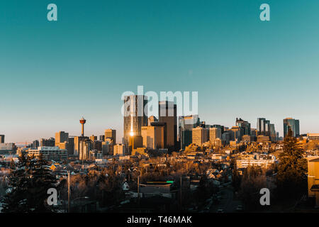 Calgary skyline nelle prime ore del mattino con raggi da RISING SUN riflette gli edifici di vetro. Foto Stock