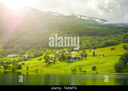 Village è situato sulle verdi pendici vicino al lago. Scenic summer view cottage di case nel villaggio di montagna vicino al lago, Norvegia. Turismo e vacanze tra Foto Stock