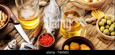 Bicchieri di birra fresca e snack salati.Chips, pesce, birra salsicce sul tavolo.Football fan parte Foto Stock