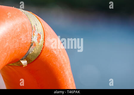 Vita arancione boa in piscina. orange salvagente su uno sfondo di acqua. Salvagente, per il caso di emergenza. La vacanza estiva concetto. Sicurezza arancione Foto Stock