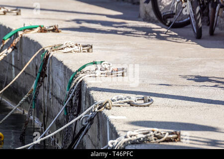 Nautica catena di ancoraggio con la formazione di ruggine nel molo. Foto Stock