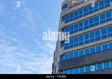 Moderno edificio residenziale di vetro e cemento contro un cielo blu Foto Stock