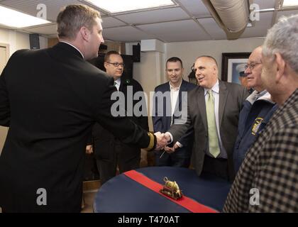 BOSTON (14 marzo 2019) della Cmdr. Morgan Roberts, comandante della Arleigh Burke-class guidato-missile destroyer USS Jason Dunham (DDG 109), saluta il consigliere della città ed Flynn, Boston City Council, nella sua cabina a bordo della nave. Il consigliere era accompagnato dal sost. David Biele e altri funzionari di Boston per accogliere l'equipaggio per la città storica. Foto Stock