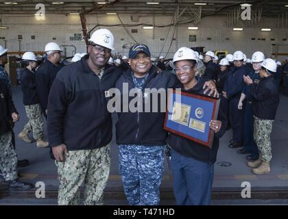 NEWPORT NEWS, Va. (14 marzo 2019) Master Chief aeromobile Maintenanceman Paolo campi, da San Phillips, Barbados, assegnato alla USS Gerald Ford (CVN 78) medico di reparto, riceve una placca da Ford Chiefs pasticcio dopo che egli è rediretto a terra. Ford è attualmente in fase di post-shakedown disponibilità presso Huntington Ingalls Industries-Newport News la costruzione navale. Foto Stock