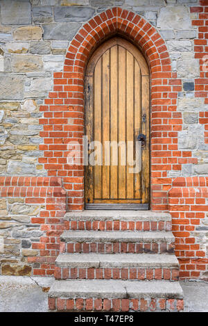 Pietra e mattoni dettagli esterni della cattedrale di Christ Church, mattone e cemento scale che conducono ad un legno porta laterale Foto Stock