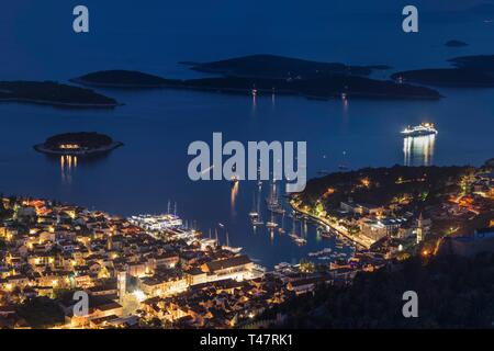 Vista sulla città di Hvar con il porto e le isole Pakleni di notte, l'isola di Hvar, Dalmazia, Croazia Foto Stock