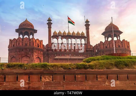 Red Fort di Delhi vista anteriore con indiana bandiera nazionale all'alba con moody sky Foto Stock