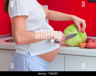Donna incinta nella preparazione degli alimenti. Foto Stock