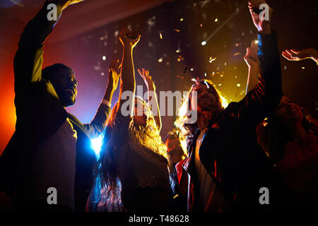 Eccitata la gente ballare in concerto in discoteca Foto Stock