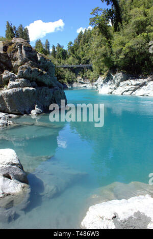 Il magnifico blu ghiaccio di Hokitika gola in mezzo al verde intenso della foresta circostante, la possibilità di essere raggiunto dal ponte girevole Foto Stock