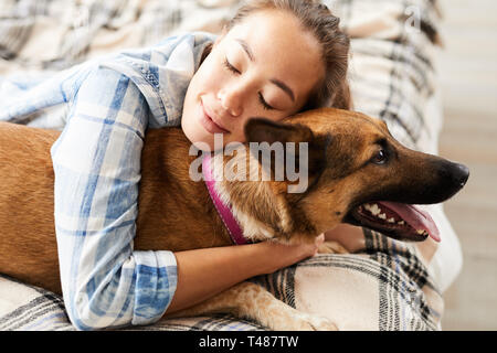 Donna asiatica abbracciando il cane Foto Stock